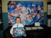 Bradley Giatras stands next to the 3rd grade masterpiece,”Cherry Blossoms”  which he helped paint.