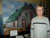 Braden Radle stands next to the 6th grade masterpiece depicting Max and Marianne Barker’s barn, which he helped paint.